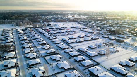 toma aérea de casas en un barrio cubierto de nieve en invierno, día nublado, toma desde arriba, toma de paralax