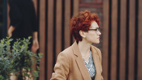 mujer de negocios sentada en un banco al aire libre y usando una computadora portátil