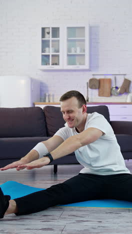 caucasian during workout at home. young man doing slopes and exercising in living room at home during the quarantine vertical video