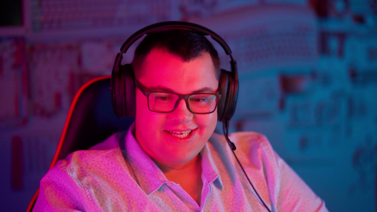 Happy Young Man with Gaming Headset Talking in Neon Lit Room