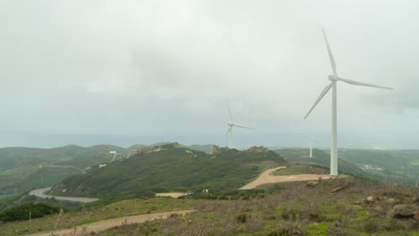 Windmill-spinning-in-clouds-near-Gibraltar,-time-lapse-view