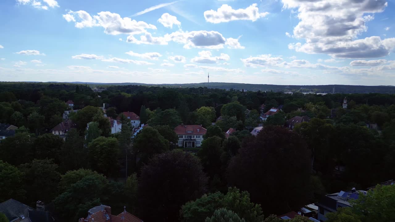 베를린의 주거 지역인 니콜라세 (nikolassee) 는 울창한 숲 속에 자리잡은 집들로 도시 지평선이 지평선에서 보인다.