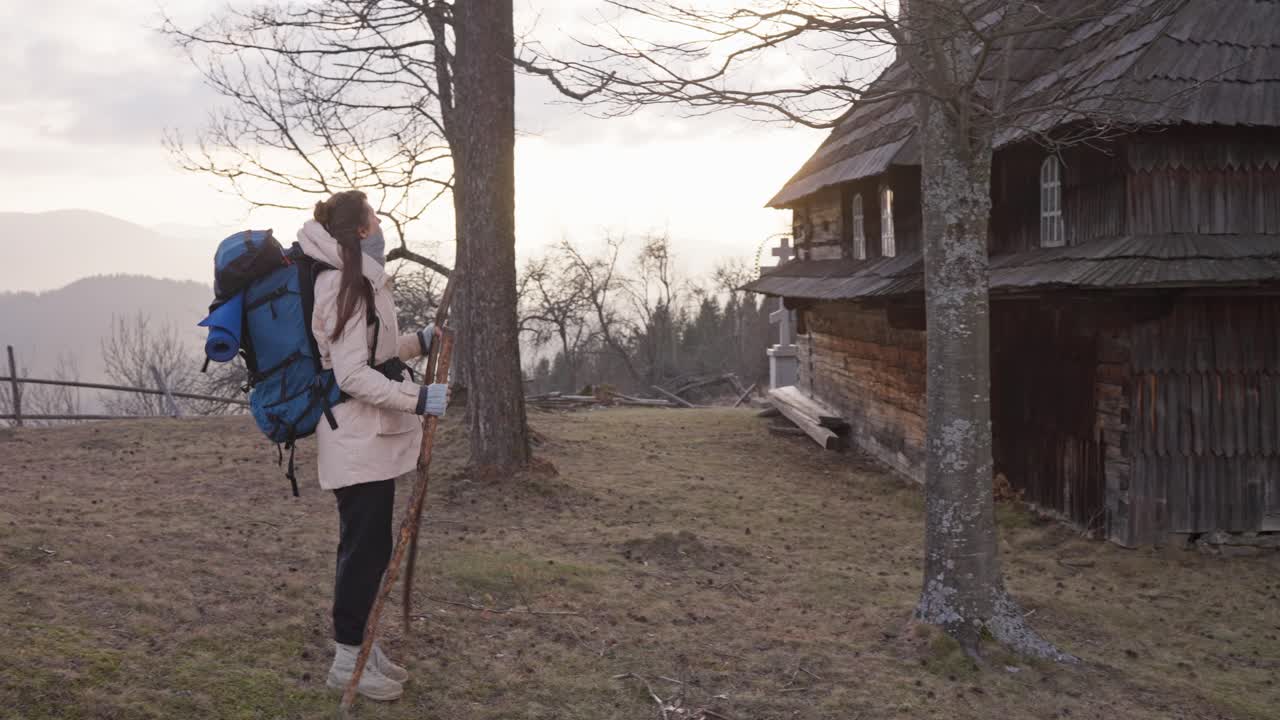 Backpacker near a wooden church in the mountains
