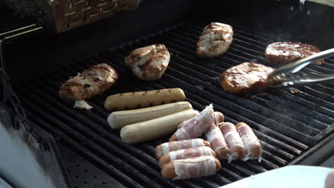 slowmotion shot of meat being put on a gas grill on a sunny day