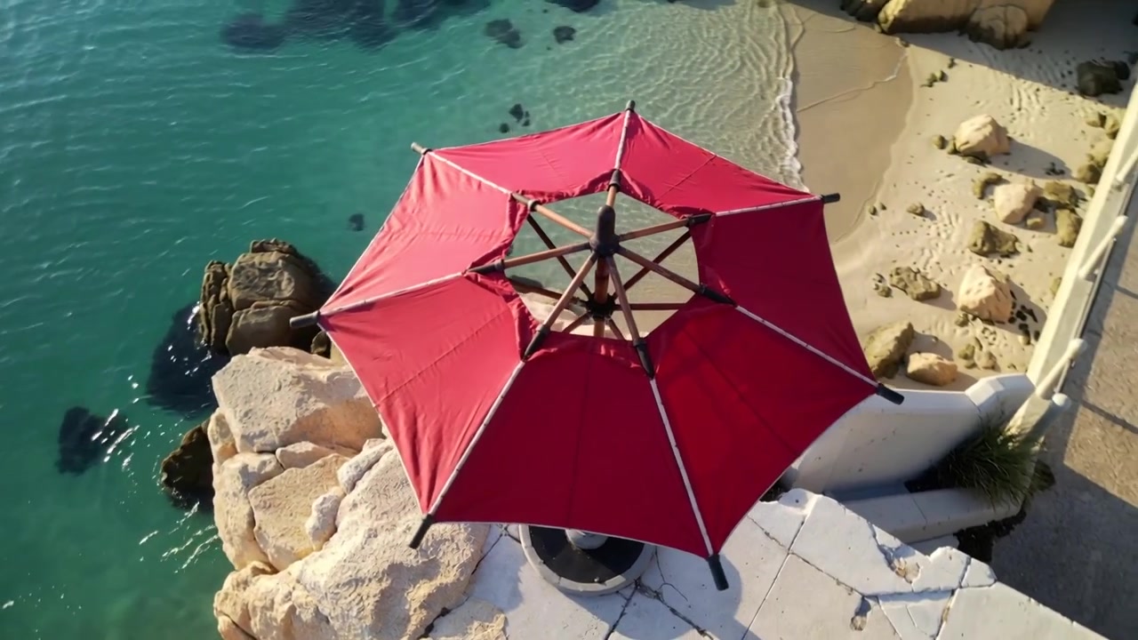 Movimento laterale della telecamera che svela un ombrellone rosso da patio su una piattaforma di pietra crepata, rivelando una passeggiata.