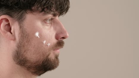 hombre aplicando crema facial