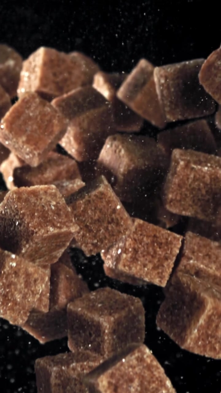 Brown Sugar Cubes Floating in Slow Motion on Black Background