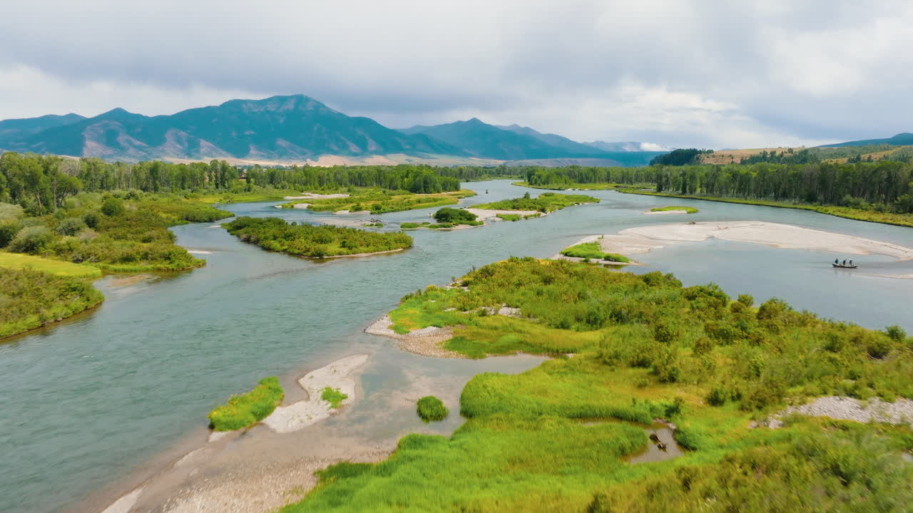 Scenic Aerial View of a Mountain River with People Fishing and Rafting
