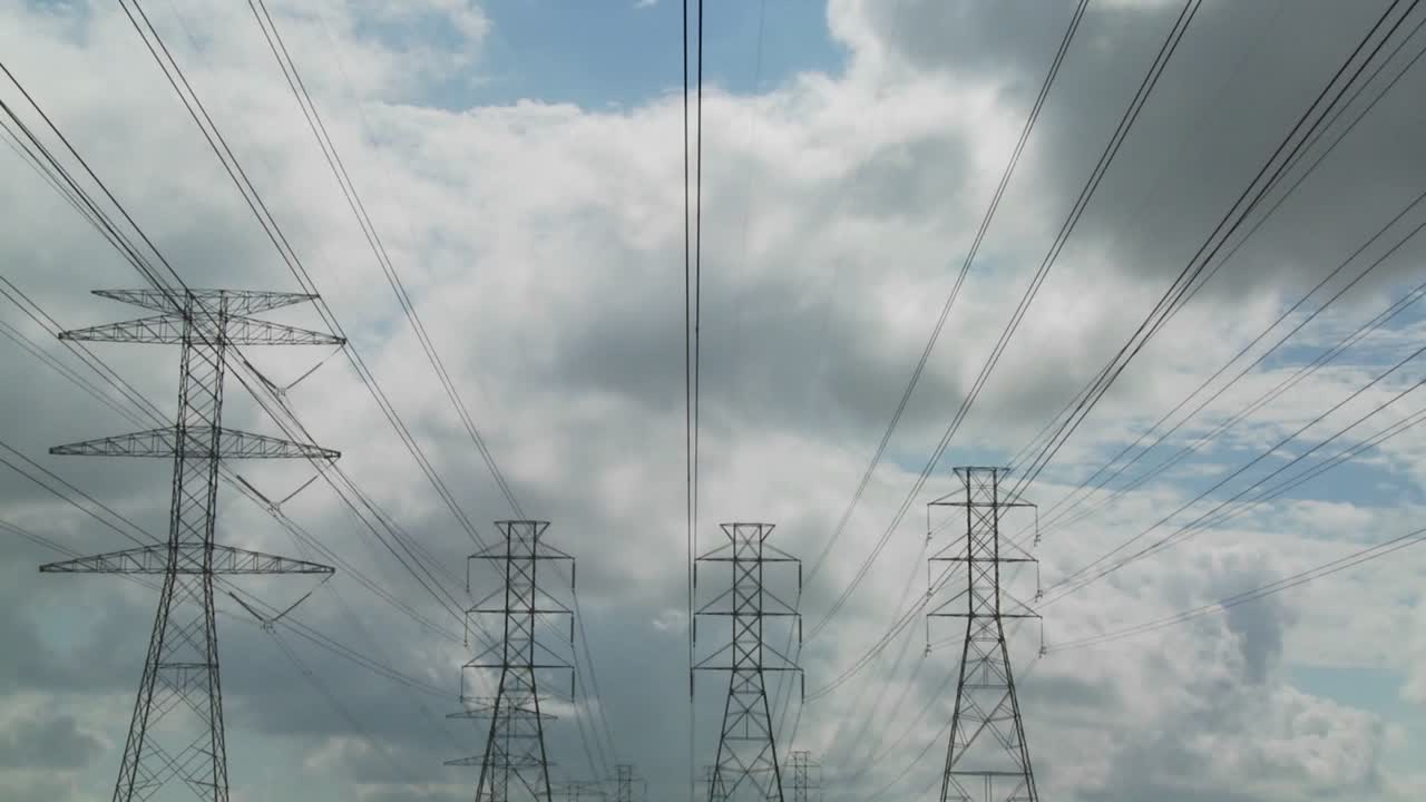 Time lapse of clouds moving behind high tension wires and power lines 2