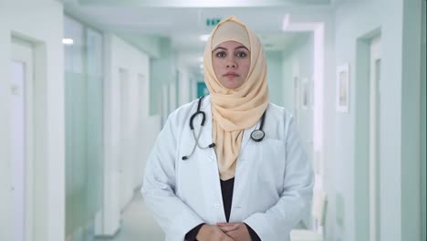 serious muslim doctor looking at the camera