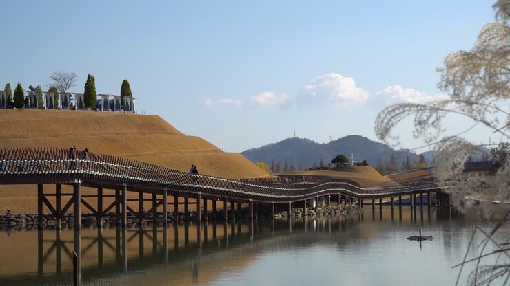 Visitatori che ammirano il panorama dal Ponte dei Sogni nel Giardino del Lago del Giardino Nazionale di Suncheonman Bay, Parco Ecologico della città di Suncheon, Corea del Sud