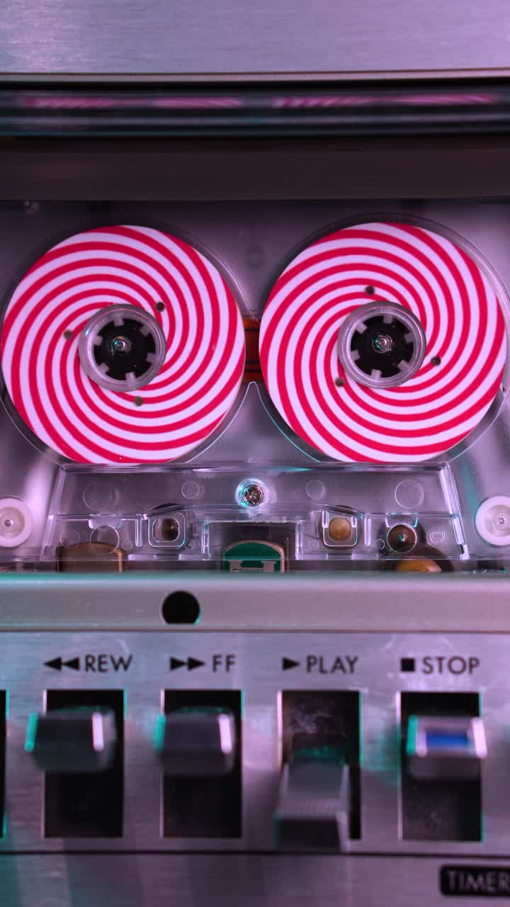 Vertical, Audio Cassette Tape With Spiral Optical Illusion Reels Spinning in Deck Player