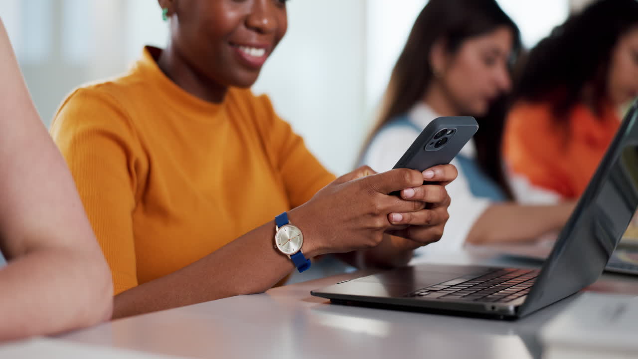 Smiling Woman Using Smartphone and Laptop in a Modern Classroom
