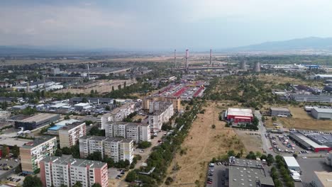 drone shot,high above the outskirts of sofia, the capital city of bulgaria,with factories and a power plant in the distance, slose to the last residential buildings