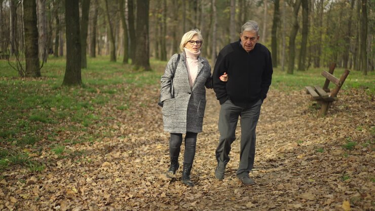 Elderly Couple Walking in Autumn Park