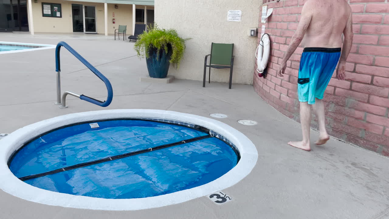 el hombre toma una ducha al aire libre en la piscina y luego quita la tapa del jacuzzi