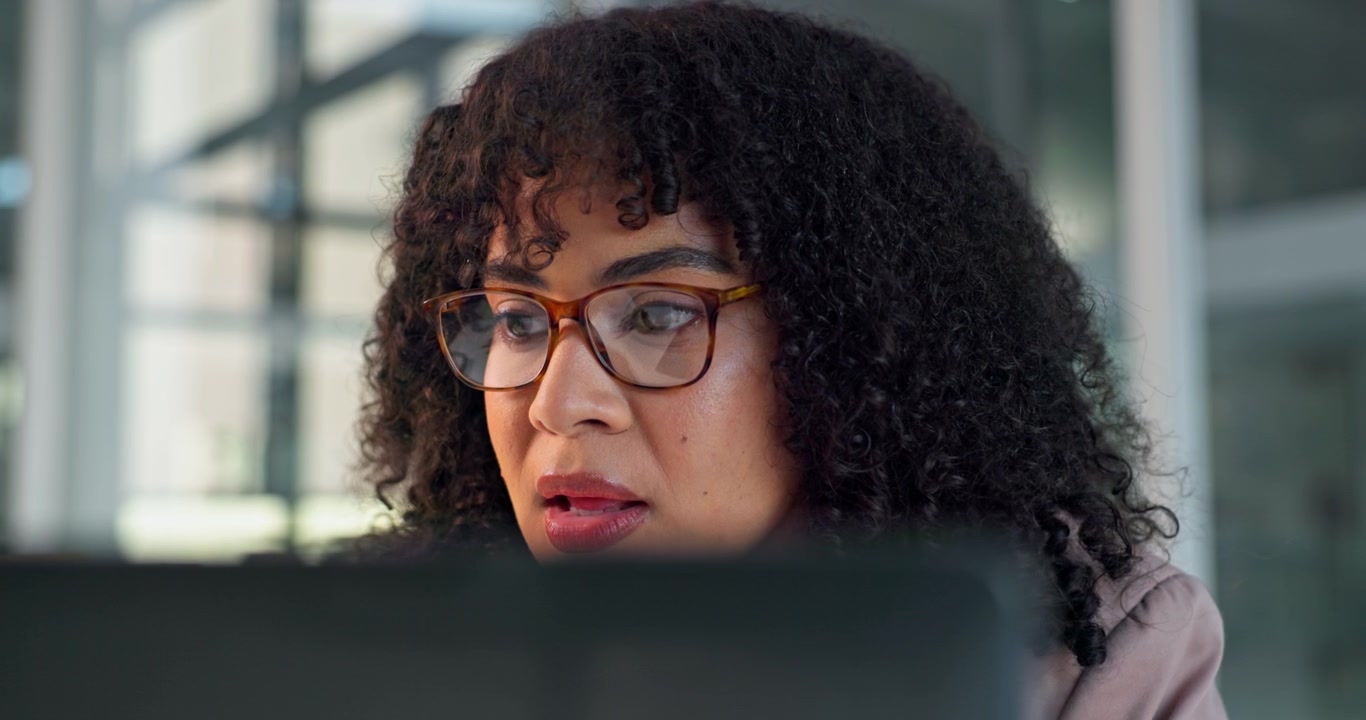 Focused Professional Woman Working on Laptop in Office
