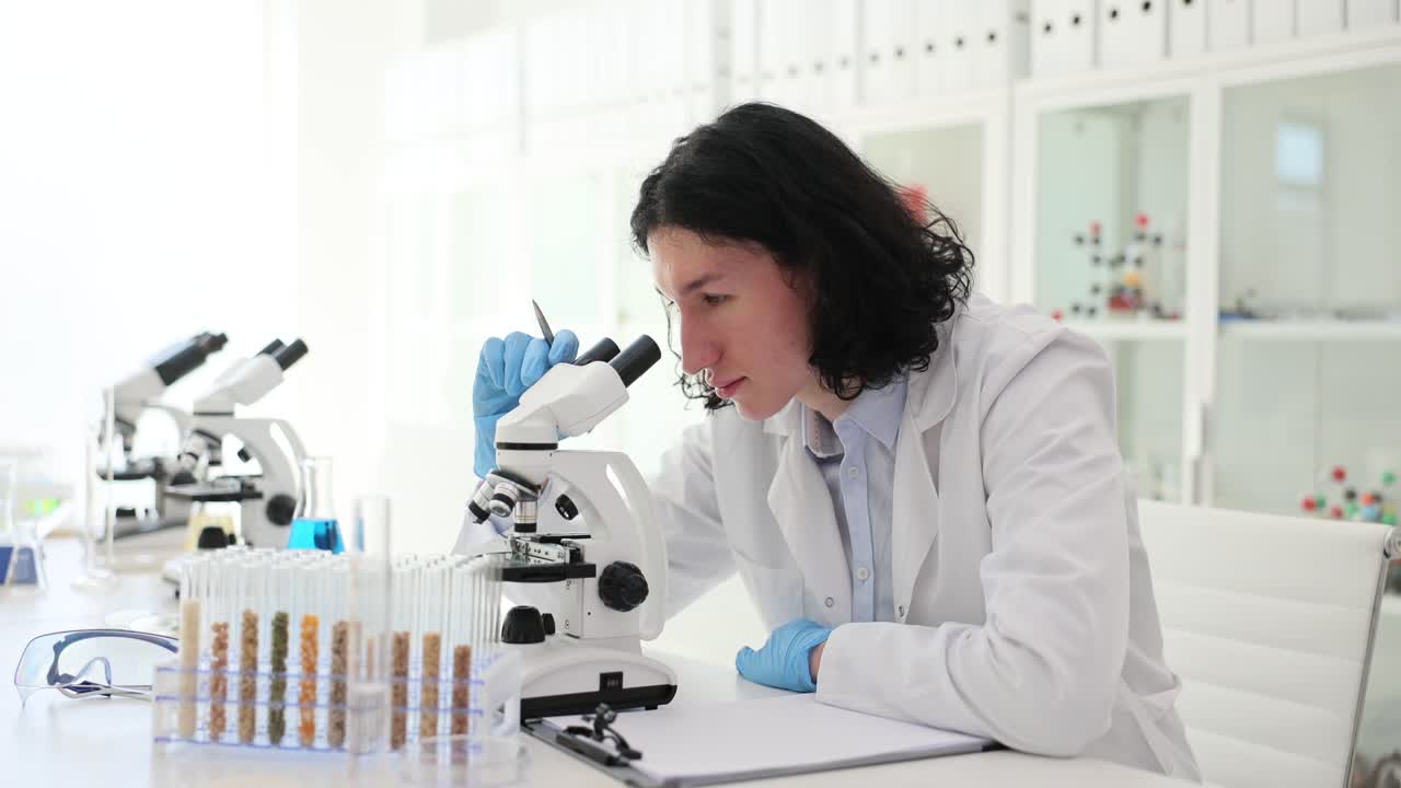 Scienziato che lavora in un laboratorio con un microscopio