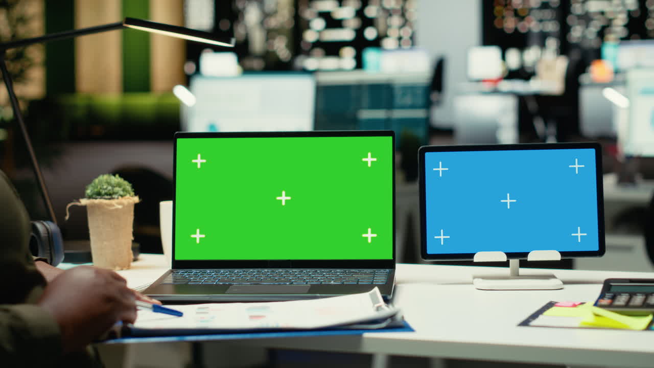 Green screen and blue screen on tablet and laptop with African american CEO
