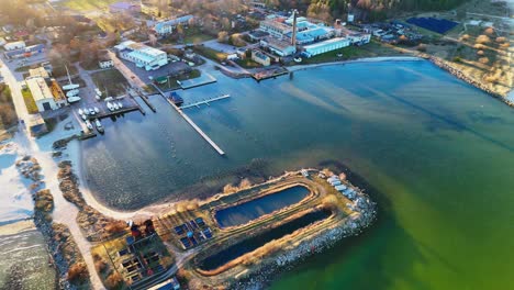 aerial view of coastal area with industrial facilities by the baltic sea in mangalsala, latvia.