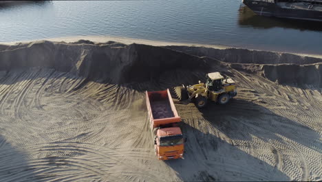 heavy machinery loading and unloading sand or gravel