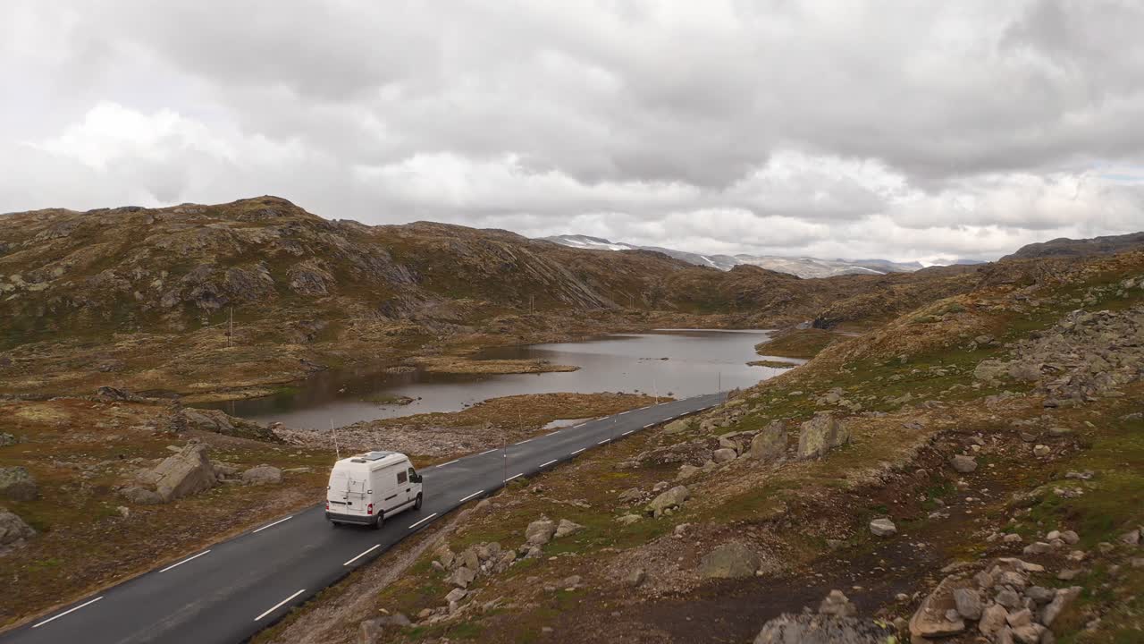 A road trip van driving through scenic Norwegian mountainous terrain, peaceful and open
