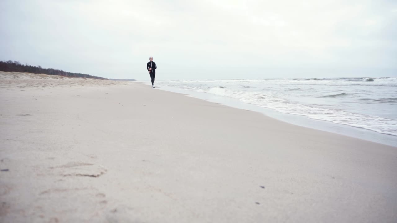 un joven está corriendo por la playa.