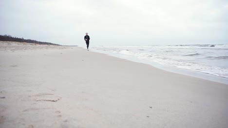 young man is running in the beach