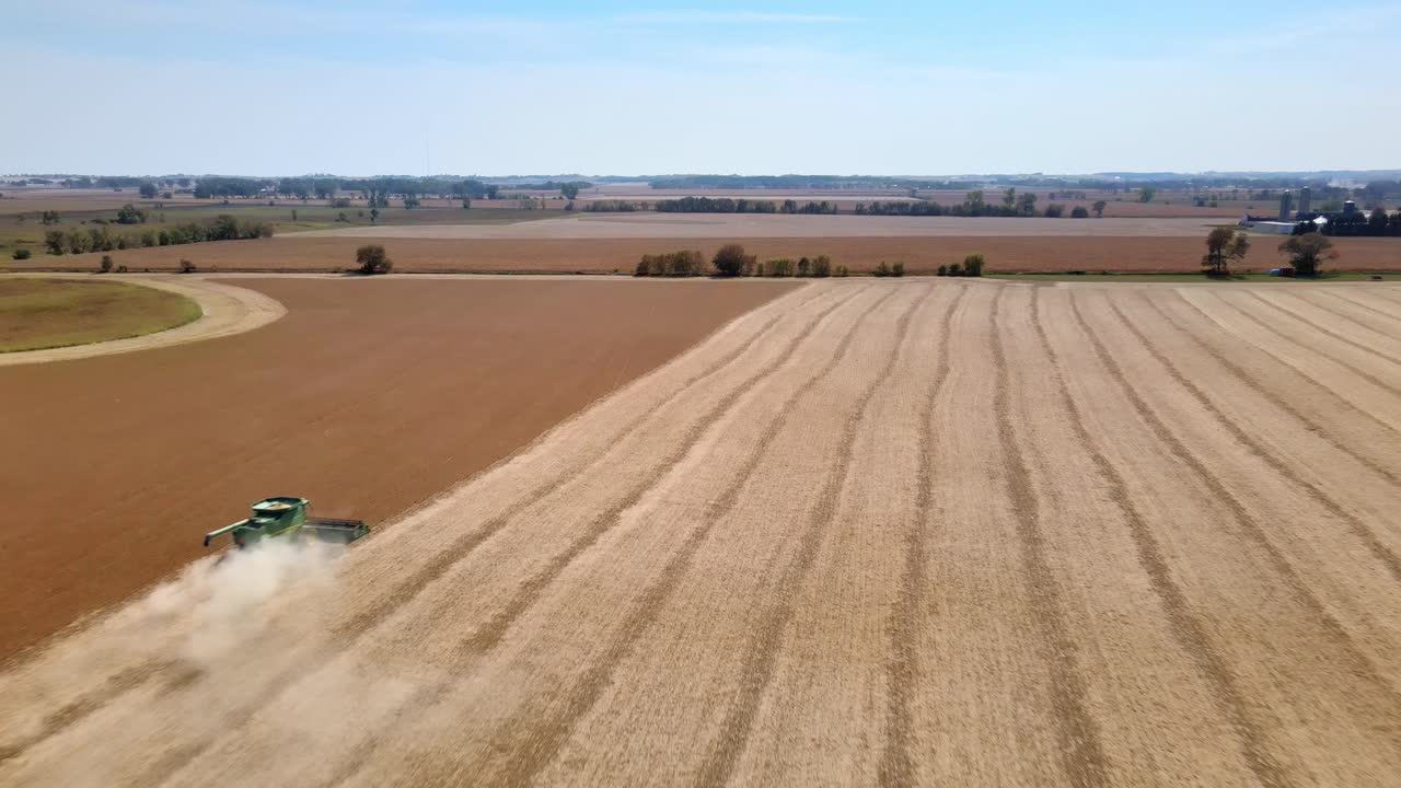 cosechadora en el trabajo cosechando trigo de campo en wisconsin - retroceso aéreo