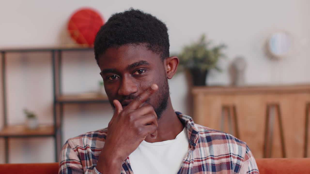 Lovely playful happy man african american smiling blinking eye, looking at camera with toothy smile