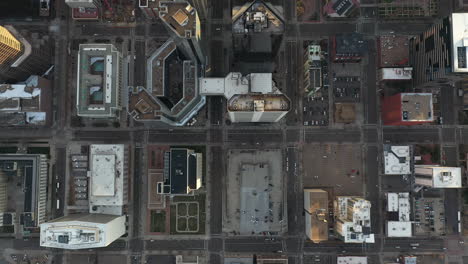 downtown denver, top down aerial view, buildings rooftops, parking lots, streets at evening, cinematic high angle drone shot