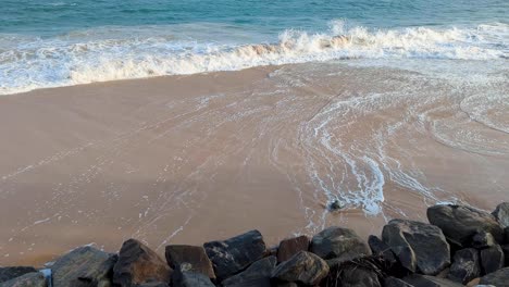 frothy whitewash waves washing up against rocky shoreline beach in tangalle, southern province sri lanka