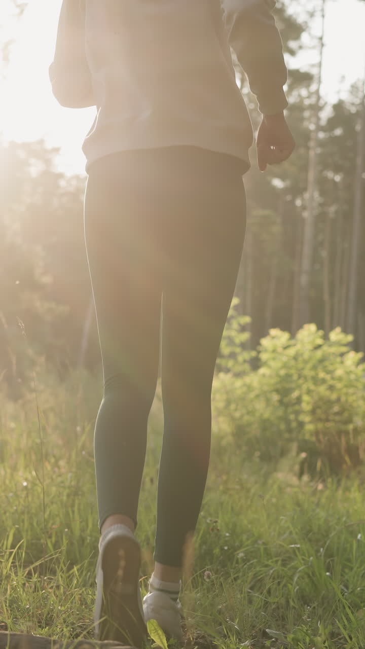 Woman takes evening run in forest. Lady athlete discovers new place for workout routine in fresh air at setting sun. Cardio exercises in nature for well-being