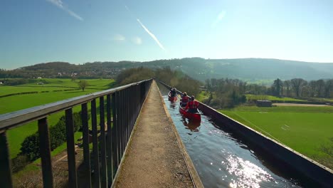 a kayak, canoe instructor takes his clients over the famous pontcysyllte aqueduct on the llangollen canal situated in north wales, outdoors extreme sports