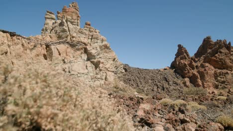 Volcanic-rock-formations-with-dry-shrubs-in-Los-Roques-de-Garcia,-Teide-National-Park-in-Tenerife,-Canary-Islands-in-spring