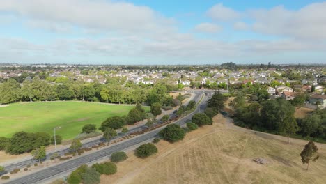 green grassy landscape in suburban park with winding trails captured from drone flying above