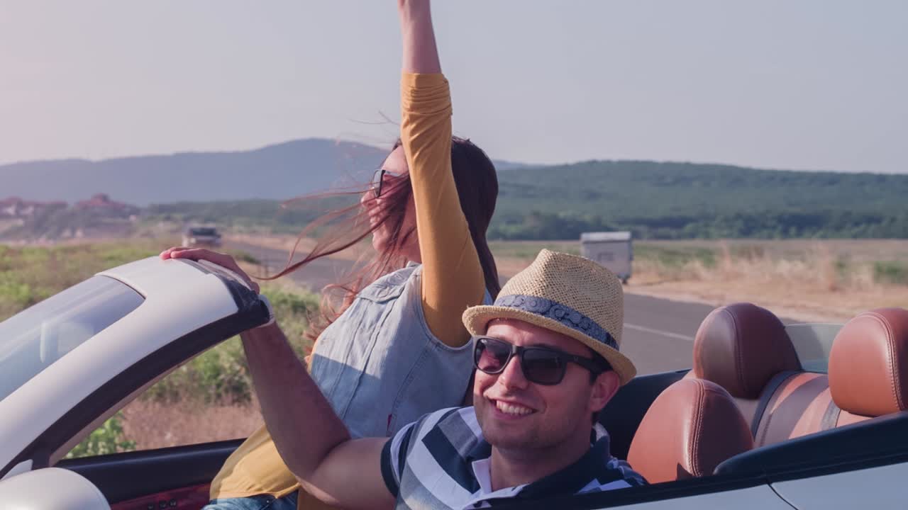 una pareja disfrutando de un paseo panorámico a lo largo de la playa en un coche convertible