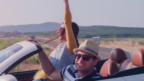 ein paar genießt eine landschaftlich reizvolle fahrt entlang des strandes in einem cabriolet