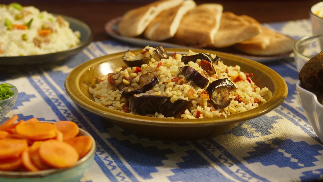poner bulgur con berenjena de primer plano, cuscús con carne en el fondo. cultura tradicional de oriente medio. delicioso arroz con carne. cocina árabe. concepto de comida casera