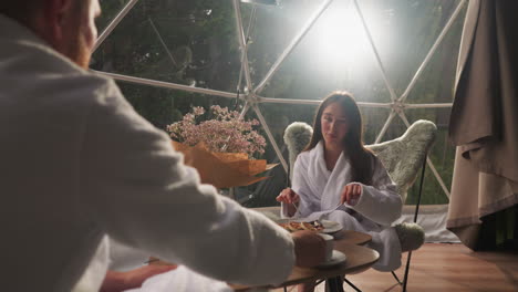 couple enjoying a romantic breakfast in a glamping dome