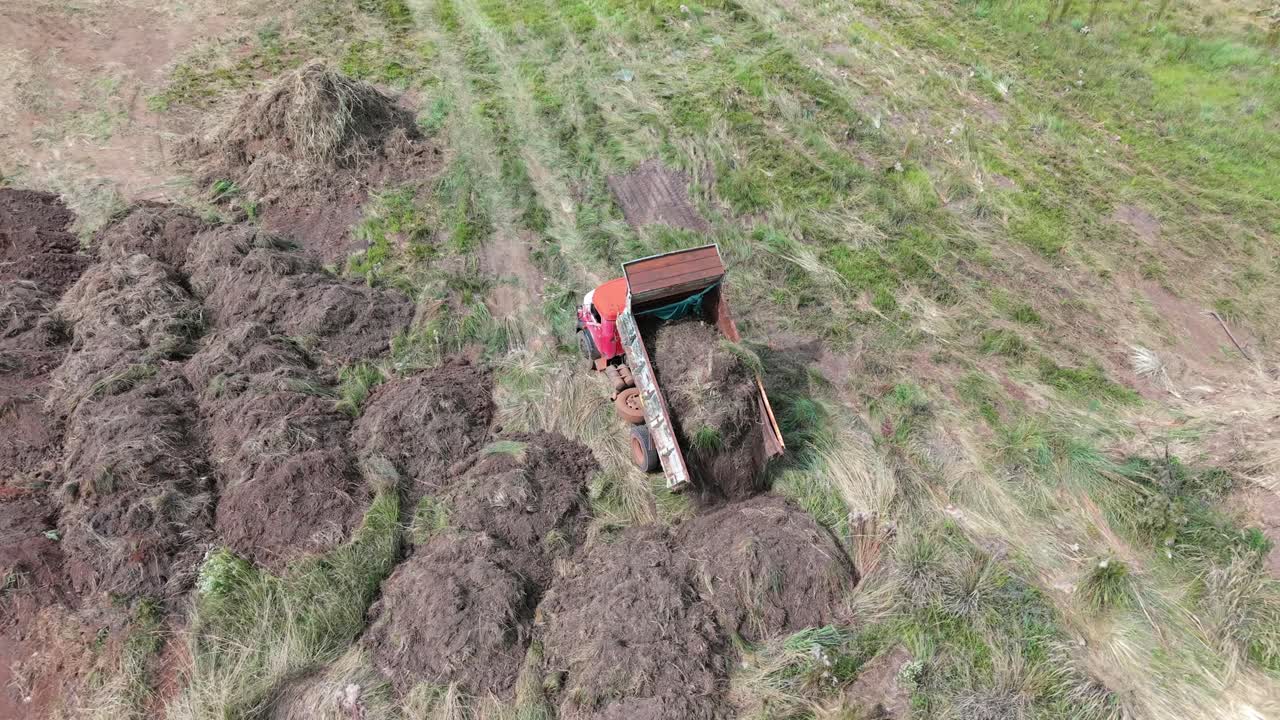 Truck machine dumping soil at an active construction site with muddy terrain.