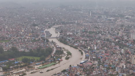 bagmati river flooding in kathmandu nepal by cloud brust heavy rain continuous destruction of housing in urban setting, drone shot reveals urgency in climate crisis alarming situation for rescue