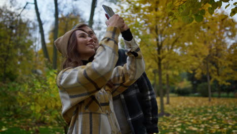 Close-up-view-of-pair-of-young-lovers-shooting-self-photos-on-smartphone-.