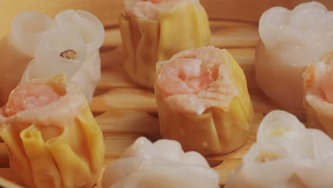 various of dim sum on wooden steamer close-up macro. steaming technique. chinese dessert food. dimsum with shrimps, fish and meat. dish in a cafe. homade. delivery
