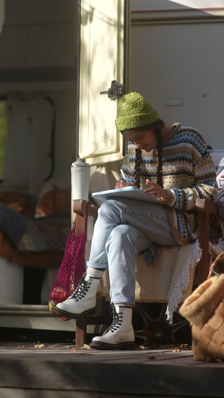 Donna che disegna all'aperto in un camper.