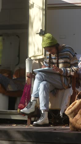 woman drawing outdoors in camper van