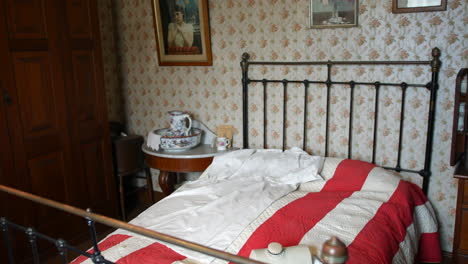 a vintage retro victorian bedroom with bed and furniture and washing bowl basin with jug