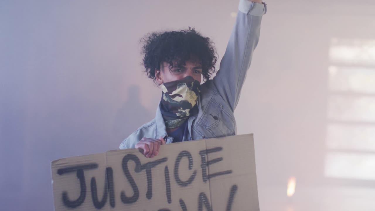 grupo diverso de personas con máscaras faciales sosteniendo carteles de protesta levantando puños