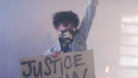 grupo diverso de personas con máscaras faciales sosteniendo carteles de protesta levantando puños