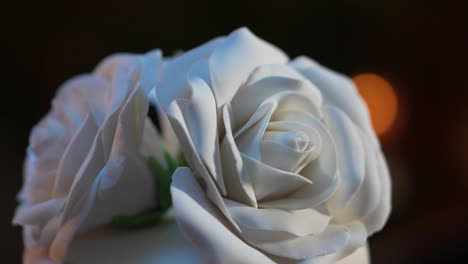 grandes rosas blancas hechas de fondante decorando la parte superior de un pastel para una celebración de bodas